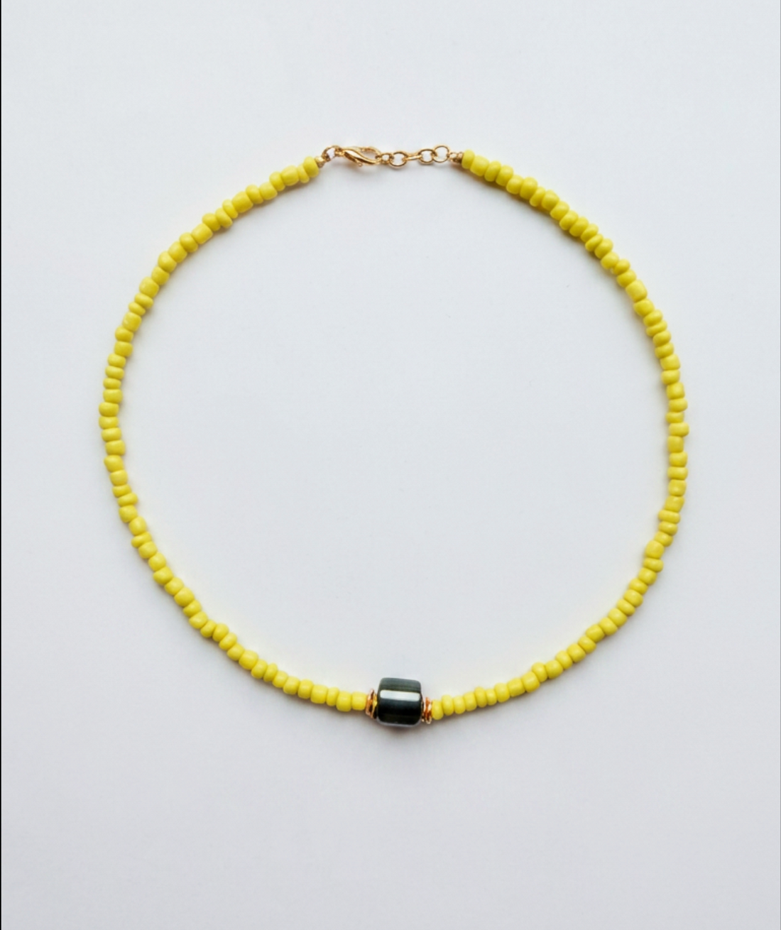 Gele kralen ketting met hematiet kraal en gouden sluiting