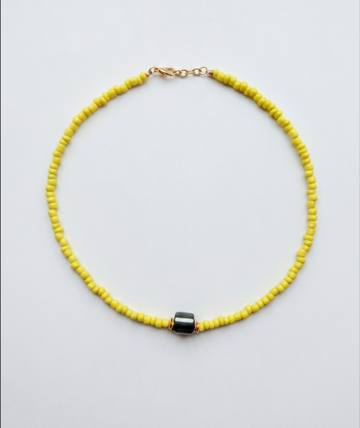 Gele kralen ketting met hematiet kraal en gouden sluiting